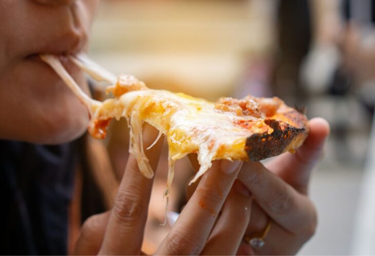 A person eating a dairy cheese pizza