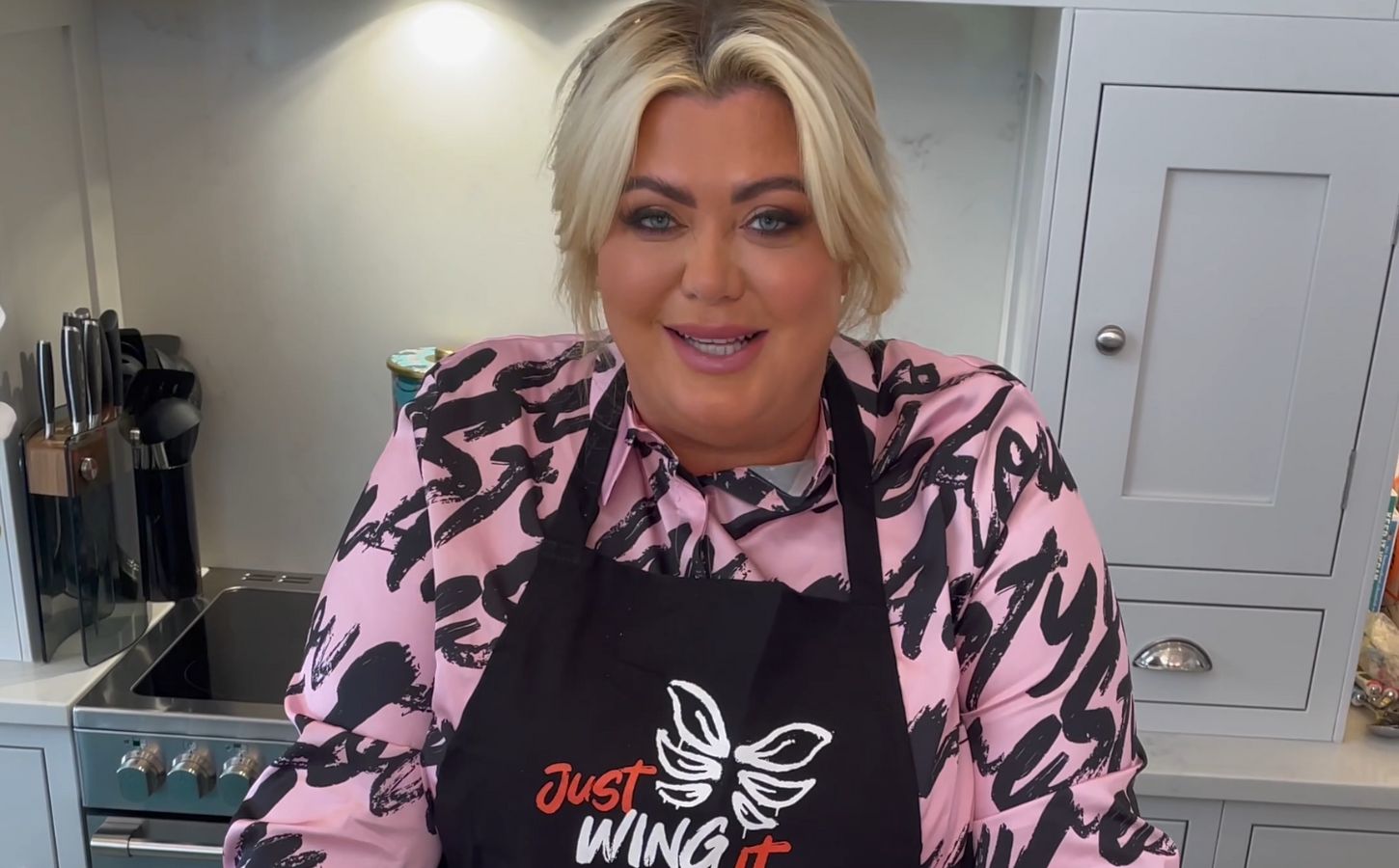 Vegetarian celebrity Gemma Collins wearing a VFC apron in a kitchen