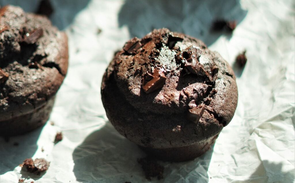 A tray full of vegan chocolate and espresso muffins set on parchment paper