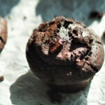 A tray full of vegan chocolate and espresso muffins set on parchment paper
