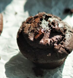 A tray full of vegan chocolate and espresso muffins set on parchment paper