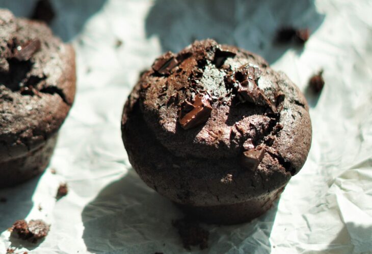 A tray full of vegan chocolate and espresso muffins set on parchment paper