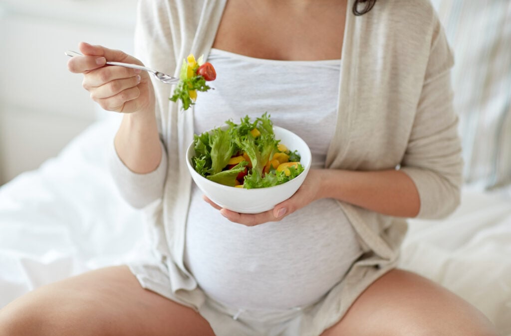 A pregnant woman eats a healthy vegan meal