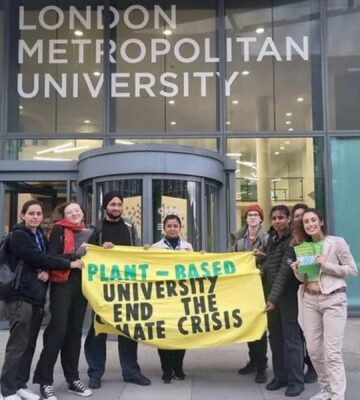 Students outside London Metropolitan University holding a banner that says: "Plant-based university end the climate crisis"