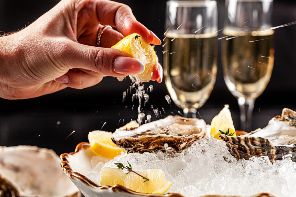 A person eating oysters are a restaurant