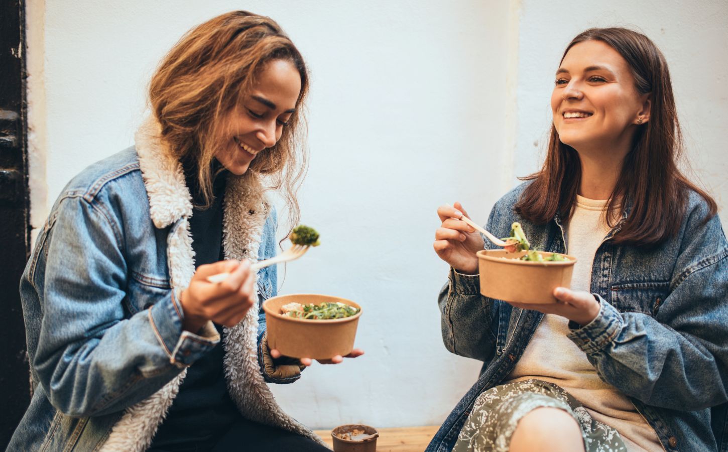 Two university students eating plant-based food together and talking