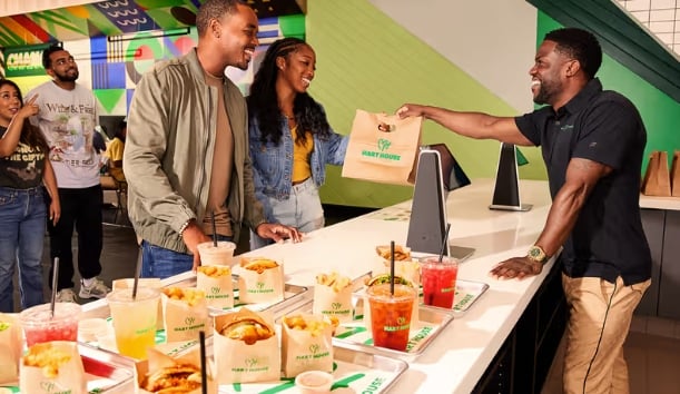 Plant-based celebrity Kevin Hart serving customers at vegan fast food restaurant Hart House