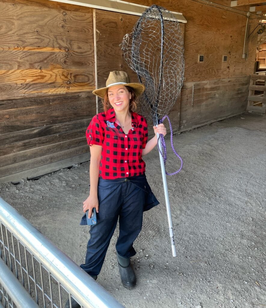 Molly Elwood, the founder of satirical Elwood's Organic Dog Meat Farm, holding a net 