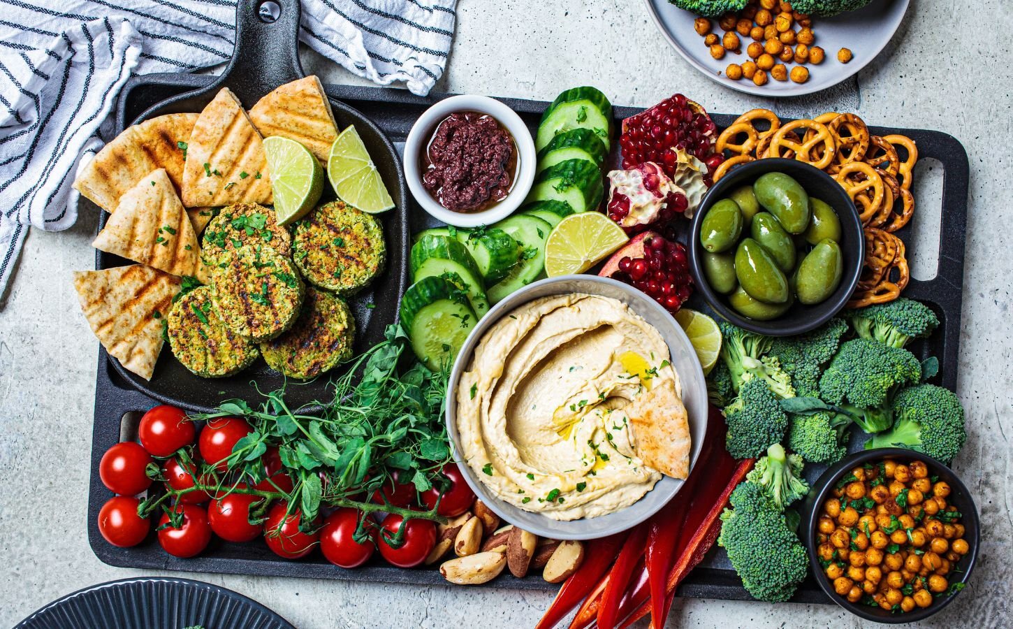 A spread of plant-based foods including broccoli, tomato, chickpeas on a plate