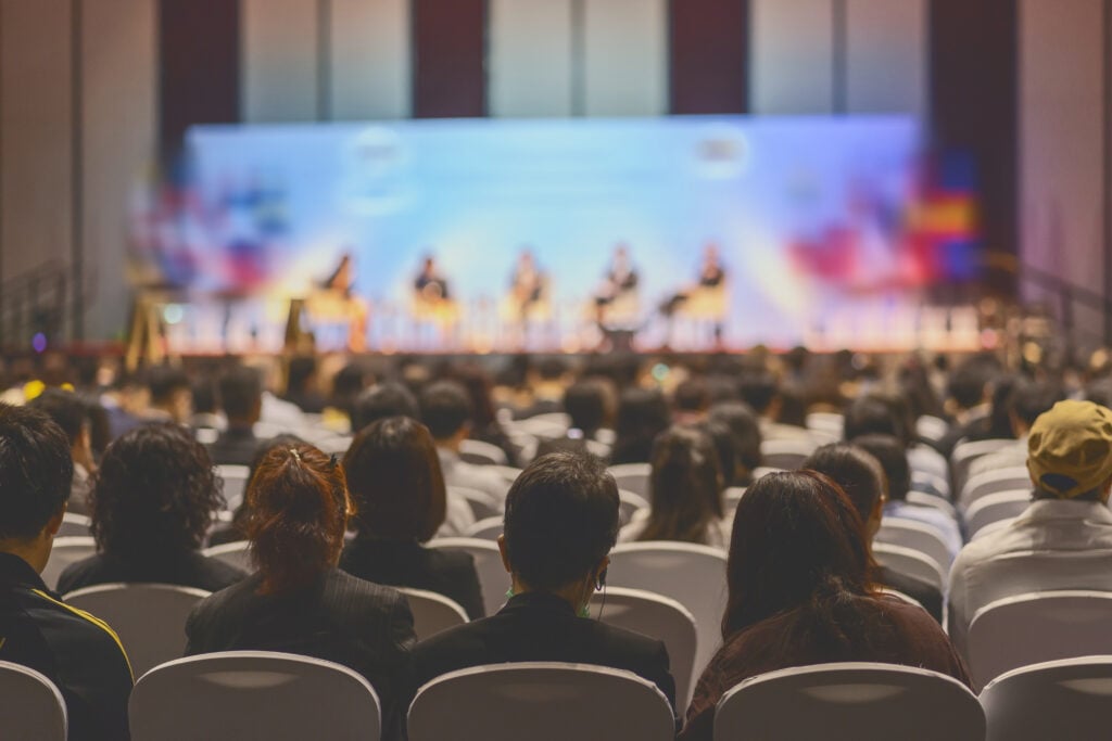 People watching a panel discussion at a conference