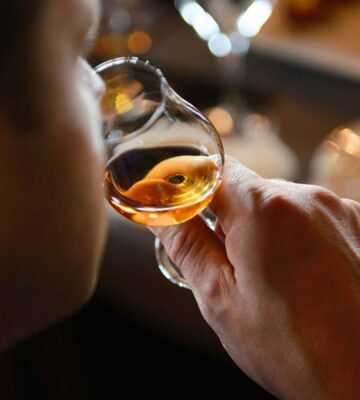 A person sampling Scotch whiskey