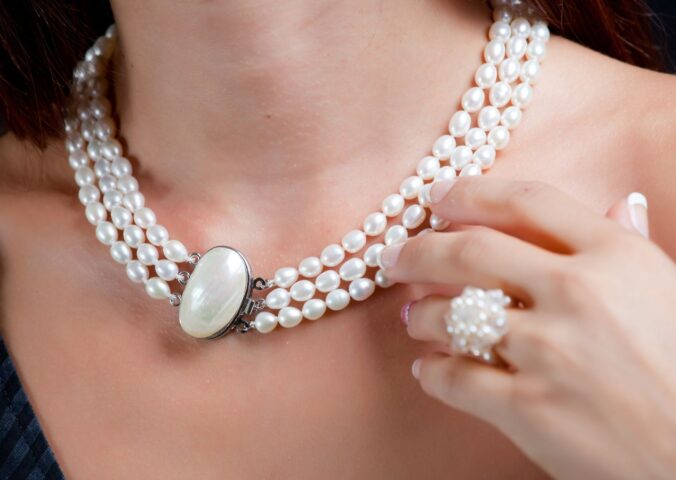 A woman wearing a pearl necklace, which is not suitable for vegans