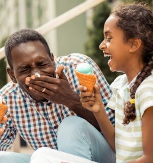 A dad and daughter enjoying vegan ice cream in the sun