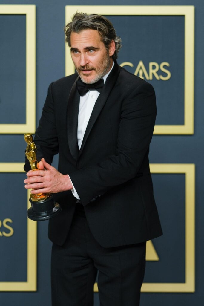 Vegan celebrity actor Joaquin Phoenix holding an Oscar after delivering an acceptance speech on animal rights