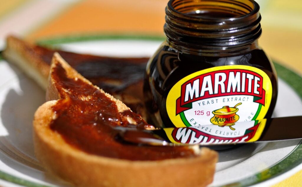 A jar of vegan-friendly spread Marmite next to some toast