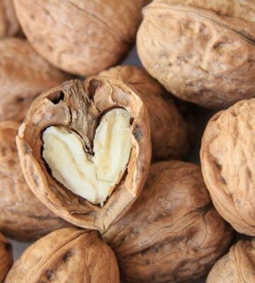 A pile of walnuts, a vegan source of omega-3, including on in the shape of a heart