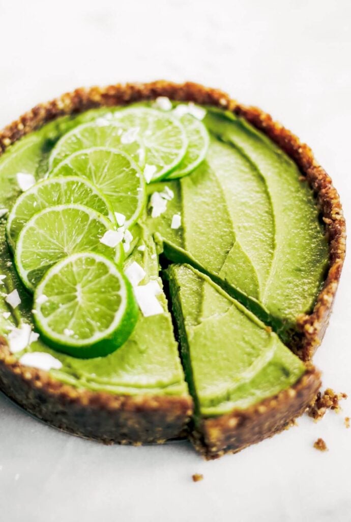 A vegan key lime pie with gluten-free ingredients and slices of lime on the top