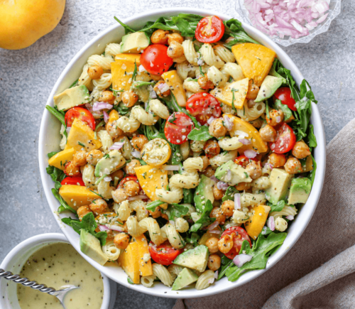 Vegan Arugula and tomato Pasta Salad featuring peach and other plant-based ingredients