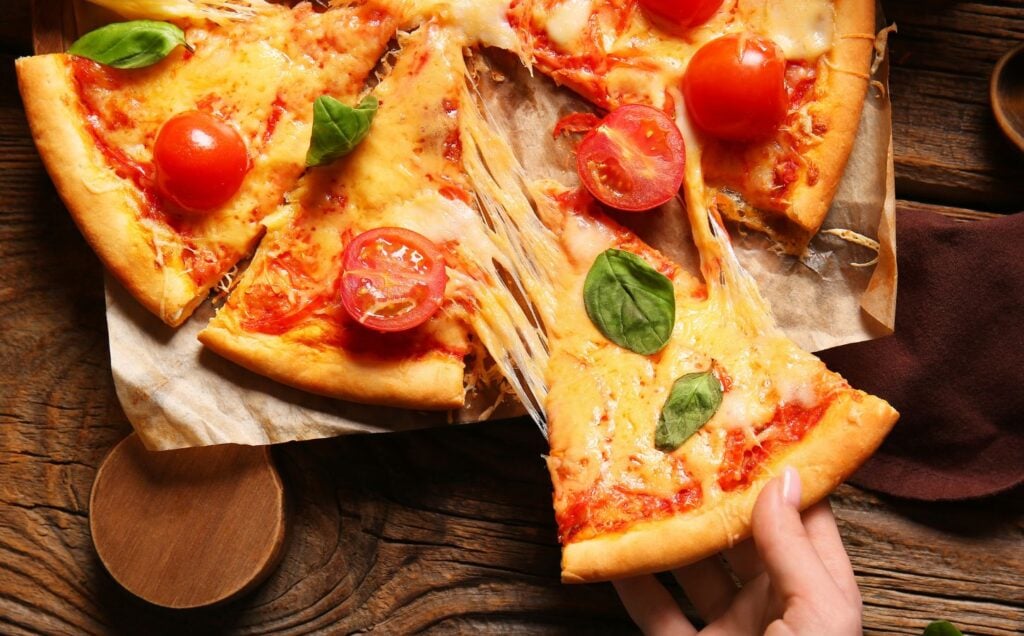 A pizza with tomatoes and cheese made from dairy milk