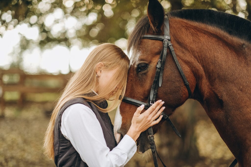 A woman hugging a horse's head