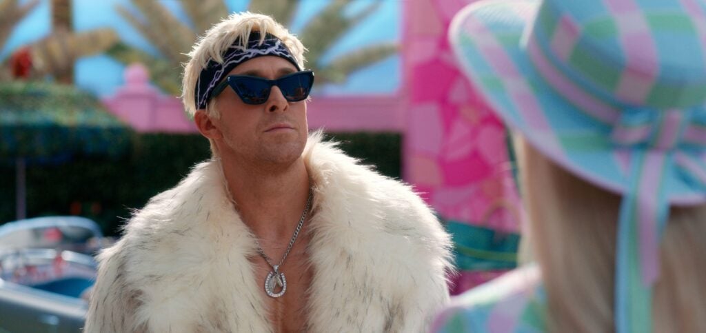 Film still from the Barbie film - Ryan Gosling's character Ken wears a faux fur coat and sunglasses