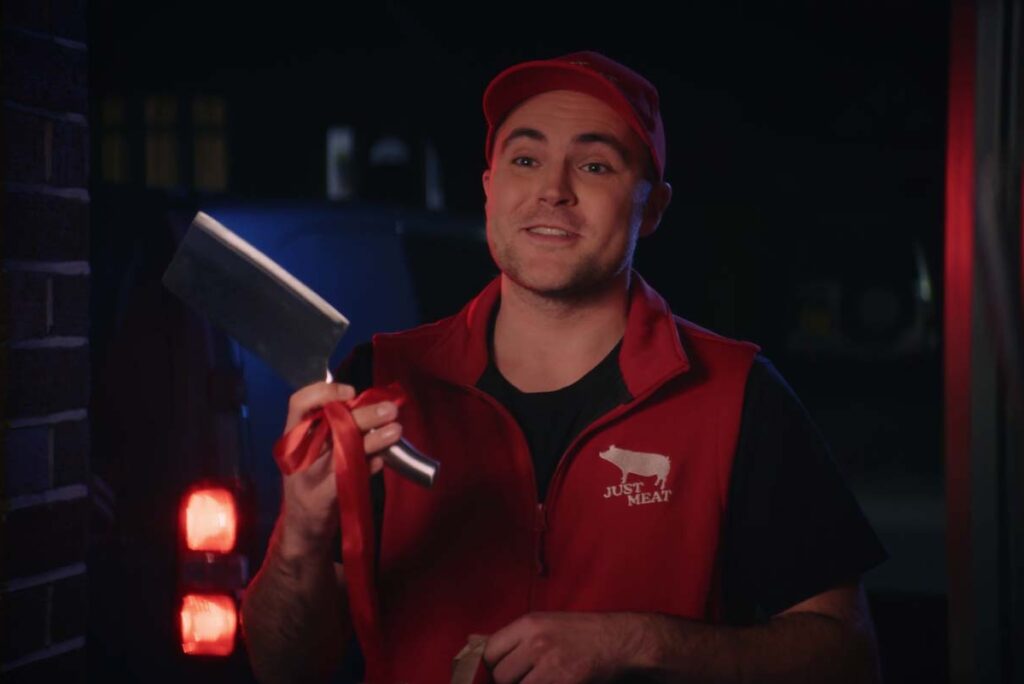 A delivery person holding a knife for pro-vegan UK TV advert 'takeaway the meat' by Viva!