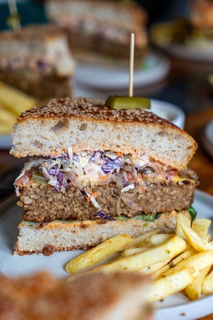 A huge burger thought to be Thailand's biggest vegan burger next to a large portion of chips