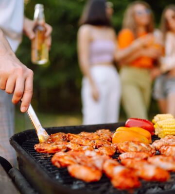 A person cooking meat, which is known to be environmentally damaging, on the BBQ
