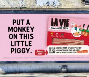 A billboard advertisement for La Vie’s new crowdfunding campaign. The ad features a packet of the brand’s vegan bacon rashers along with the message “Put a monkey on this little piggy.”