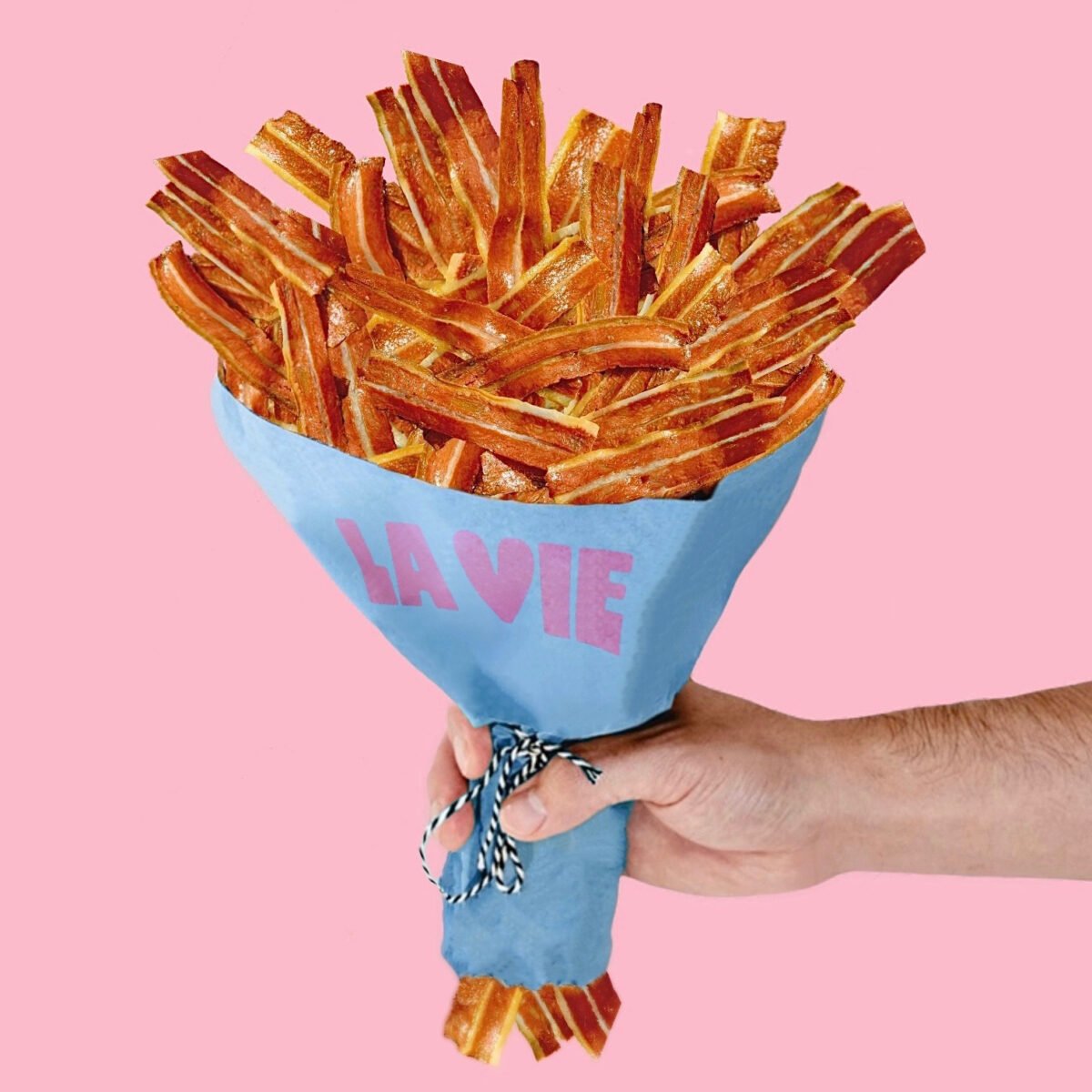 A hand holding a bouquet of vegan bacon rashers from plant-based meat brand La Vie