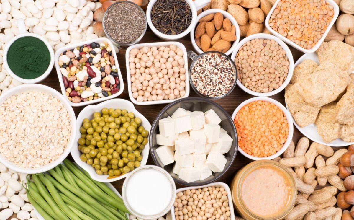 Aerial shot of assorted bowls of plant-based protein sources arranged colorfully