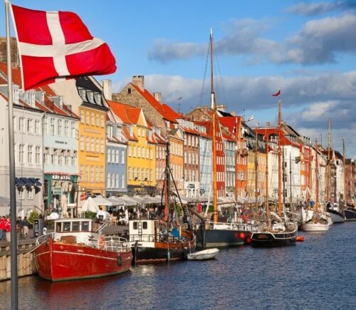 A shot of Denmark, which has just introduced a plant-based roadmap, on a sunny day with colorful buildings and the Danish flag