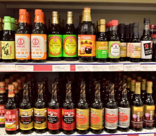 Vegan fish sauce substitutes in a supermarket, including soy sauce