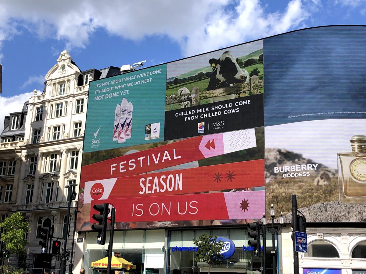 An M&S advert on display at Picadilly Circus reading "chilled milk should come from chilled cows"
