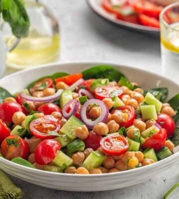 Bowl of healthy plant-based salad with vegan protein chickpeas, tomatoes and onions