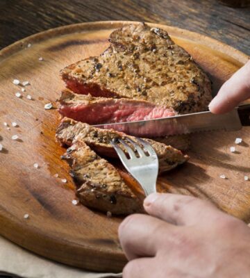 Man cutting red meat, which is linked to type 2 diabetes
