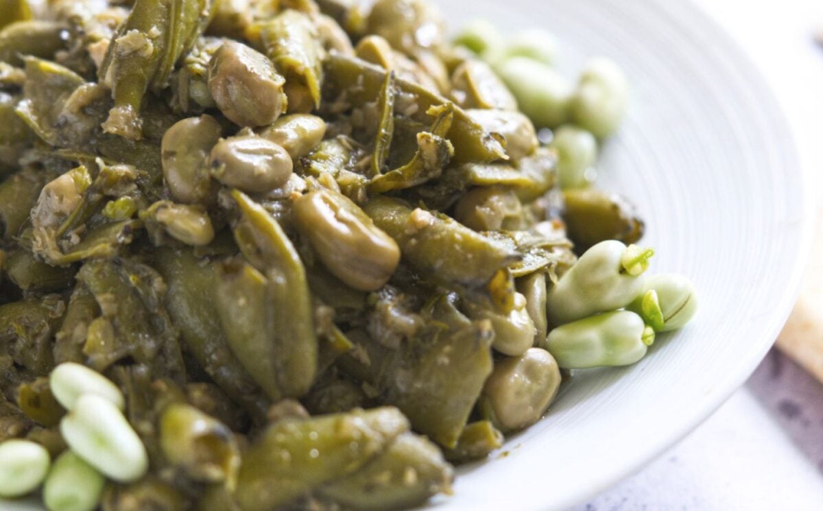 A Lebanese vegan dish consisting of garlicky broad beans on a white plate