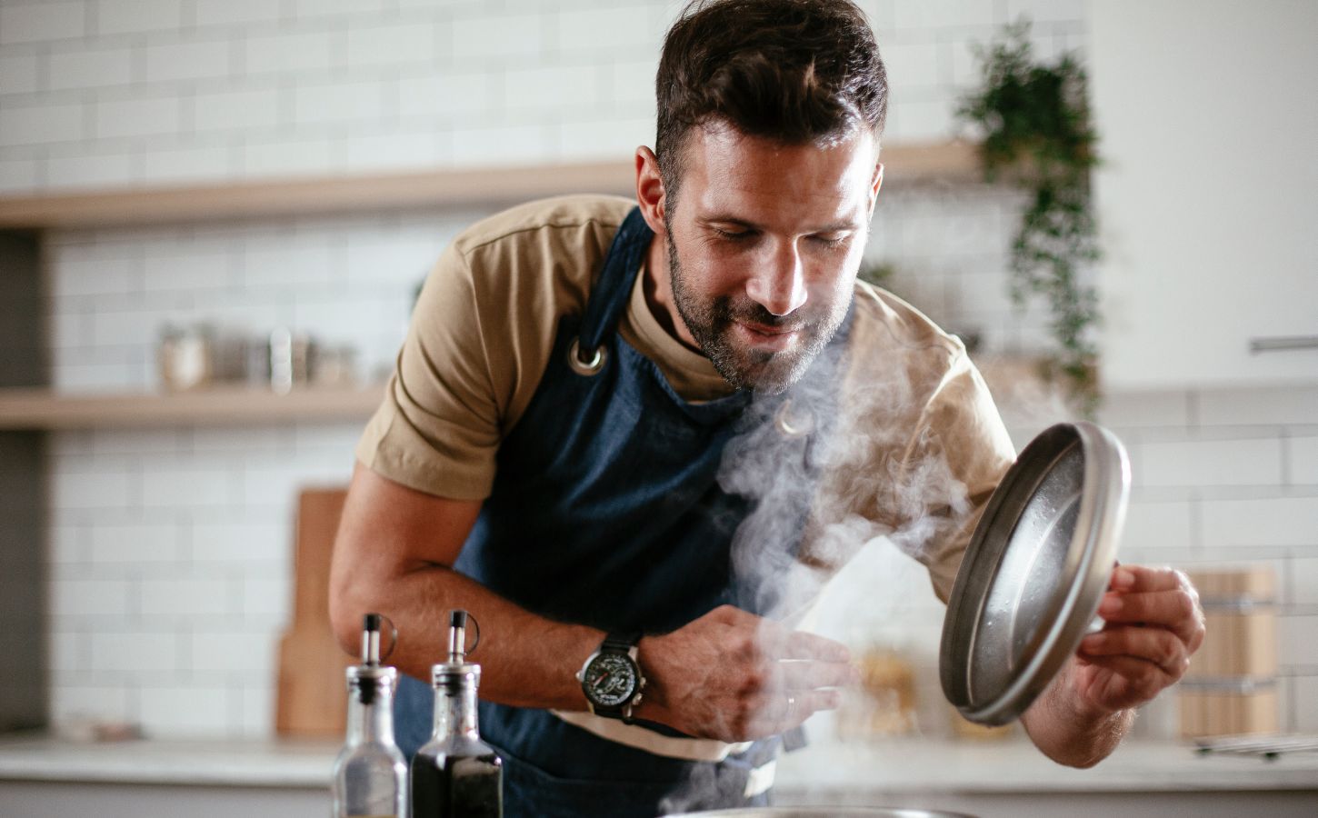 Vegan man leaning over a pan as he cooks vegan food