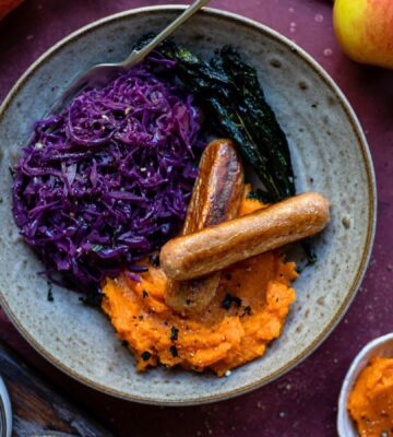 Braised red cabbage with vegan sausages and mashed potato