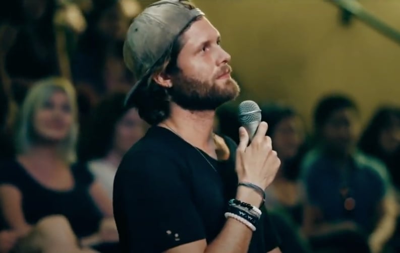 Kameron Waters holding a microphone in a still from new vegan documentary Christspiracy