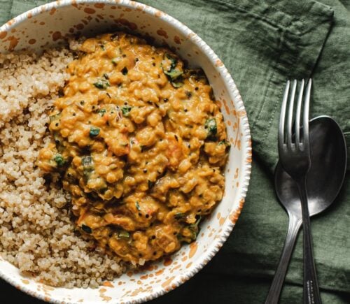 A bowl of butternut squash dahl and grains on a green towel