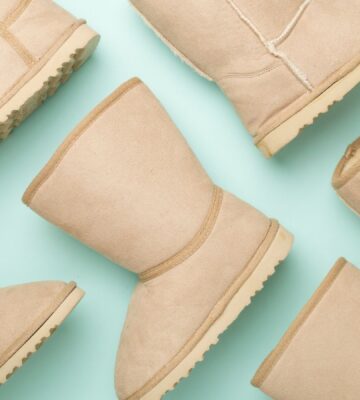 Ugg boots, which are not vegan-friendly, before a pale green background