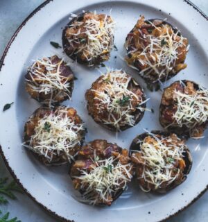 A vegan cheese, bacon, and apple stuffed mushroom being served at a Christmas party