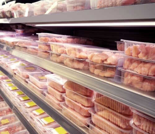 Photo of packaged raw meat products on supermarket shelves.