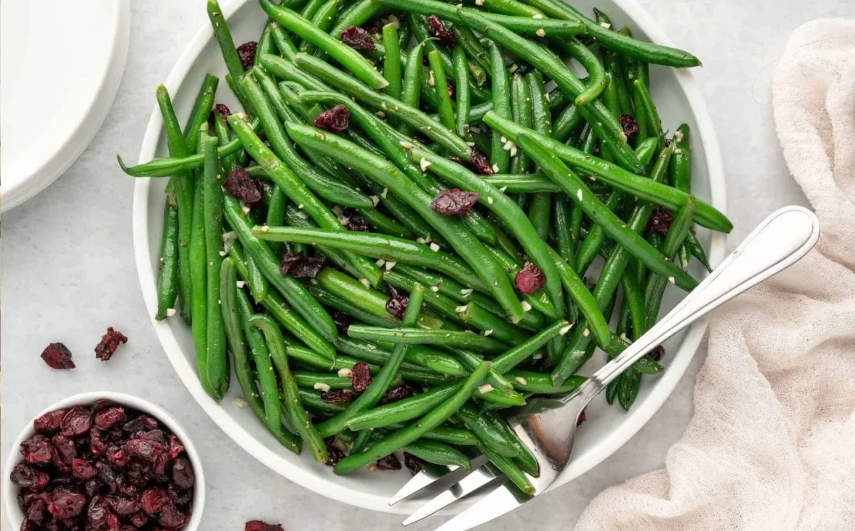 Photo shows a large bowl of whole green beans cooked with garlic.