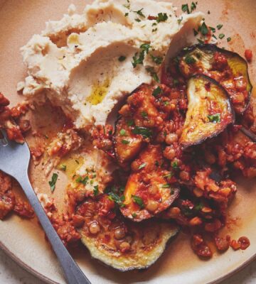 A plate of harissa aubergine served on butter bean mash