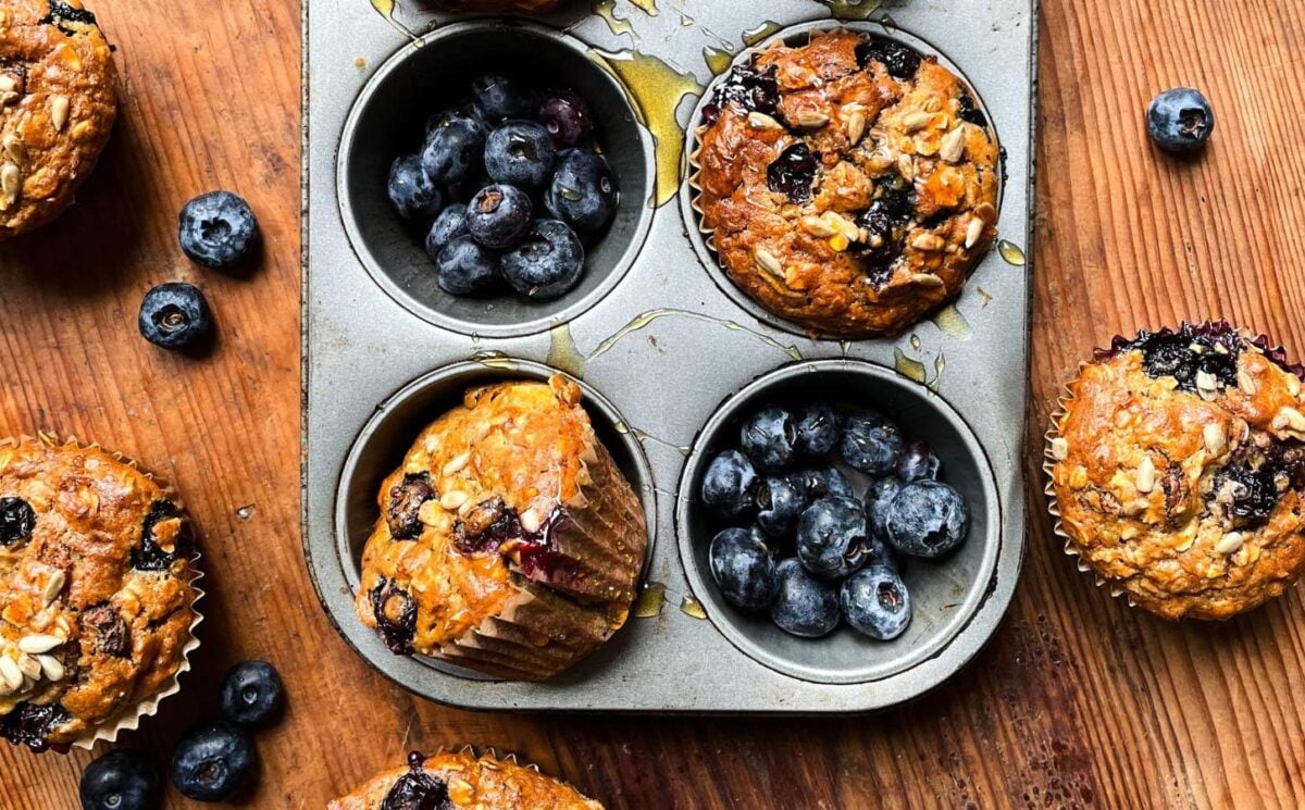 A tray of freshly cooked vegan breakfast muffins with blueberries