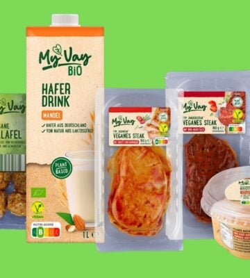Image shows a selection of Aldi's new MyVay vegan products on a dark blue background, including plant-based falafel, milk, and steak.