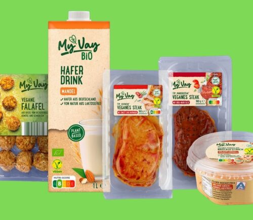 Image shows a selection of Aldi's new MyVay vegan products on a dark blue background, including plant-based falafel, milk, and steak.