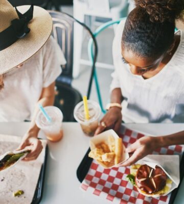 Two friends eating vegan food at a plant-based fast food restaurant